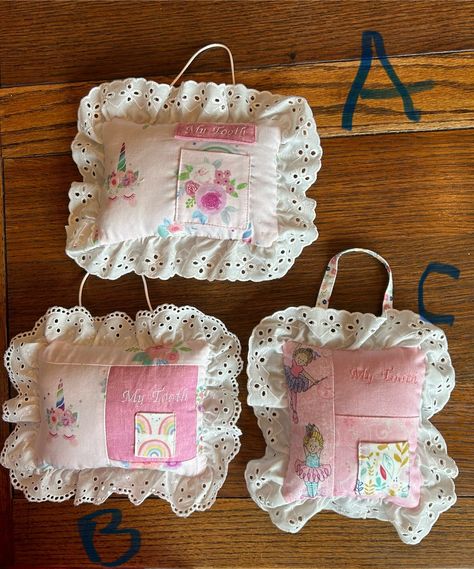 I made these tooth fairy pillows with cotton fabrics, eyelet lace, and used polyfil for stuffing.  The pillow can be added decor in child's bedroom on the bed, shelf, or hang from a doorknob with the added handle.  The tooth pocket is lined and all of the pillow is machine stitched.  This pillow measures approximately 6" x7" and makes a great baby shower gift.  Each one is unique.  Also, the Tooth Fairy really appreciates the help and convenience of easy finding the little one's lost tooth! Waldorf Tooth Fairy Pillow, Tooth Fairy Pillow Pattern Free, Tooth Fairy Diy, Tooth Fairy Pillow Pattern, Bed Shelf, Fairy Pillows, Homemade Pillows, Tooth Fairy Pillows, Fairy Room