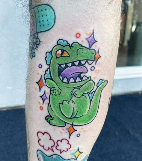 Halt! It's the cutest little Reptar tattoo by @ktrantattoos! 🦖✨ ㅤ ★ TOOFAST.COM ★⁠ ㅤ ㅤ ㅤ ㅤ ㅤ ㅤ #rugrats #reptar #90skids #90scartoons #rugratstattoo #tattoosnob #tattoolove #tattooideas #tattoostagram #instatattoos #tattooartist #tattooart #inkedup #tattooist #colortattoo #colortattoos #tattoocolor Reptar Tattoo, Cartoon Tattoo Ideas, 90s Tattoos, Animated Shows, Nostalgic 90s, Cartoon Tattoo, Pokemon Tattoo, Alien Tattoo, Flash Tattoo Designs