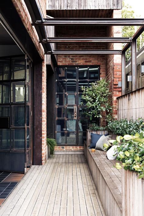 A lemon tree flourishes in the corner of this home's courtyard. Cypress boards line the deck and built-in seating area | Photography: Martina Gemmola | Styling: Ruth Welsbey Industrial Cottage, Mediterranean Mansion, Industrial Style Home, Australian Interior Design, Mediterranean Style Homes, Vintage Industrial Decor, Industrial Architecture, Industrial Interior Design, Tropical Home Decor