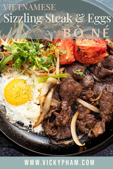 Bò Né is a delicious dish combining the best Vietnamese and French cuisine. It is a hearty and satisfying breakfast dish that is also perfect for any time of day. The seared sizzling steak and eggs are served with pate, tomatoes, onions, sunny-side-up fried egg, pickled vegetables, and a baguette for scooping. Korean Keto, Asian Breakfast Recipes, Vietnamese Steak, Breakfast Steak And Eggs, Korean Marinated Eggs, Chinese Egg Drop Soup, Vietnamese Breakfast, Marinated Eggs, Dinner Eggs