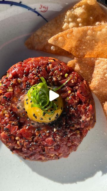 Amine Laabi on Instagram: "ASIAN STYLE BEEF TARTARE Ingredients: * 250g high-quality fresh beef, finely diced * 1 tbsp hot chili crispy oil * 1 tbsp soy sauce * 1 tbsp sesame oil * 2 green onions (white part finely chopped) * 1 tbsp finely chopped pickled ginger * 1 lime zest * Salt or MSG, to taste * Freshly cracked Szechuan pepper * Sesame seeds * 2 Egg yolks * Fried wonton chips Instructions: * Mix beef with chili oil, soy sauce, sesame oil, green onions, pickled ginger, salt/MSG, and Szechuan pepper. * Transfer seasoned beef to a serving plate. * Shape into mounds and garnish with sesame seeds, egg yolks, green onions, and wonton chips. * Serve and enjoy! 🎥 @fotoshermanos #beeftartare" Asian Beef Tartare, Fried Wonton Chips, Asian Style Beef, Fried Wonton, Wonton Chips, Instagram Asian, Beef Tartare, Fried Wontons, Asian Beef