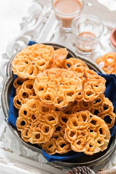 Rose cookies aka achu murukku is a traditional South Indian snack made during festivals in India. The pretty flower shape makes these murukku or cookies a very popular snack and goes perfectly with your evening tea. Festivals in India are always grand and colorful. That goes not just for clothes and decorations but for all the festive delicacies as well. Deepavali/Diwali is one of the grandest festival of lights in India and downright it’s one of my most favorite festival. I literally wait all y Sambhar Recipe, Rosette Cookies, South Indian Snacks, Flower Desserts, Christmas Donuts, Rose Cookies, Popular Snacks, Indian Dessert Recipes, Christmas Food Desserts