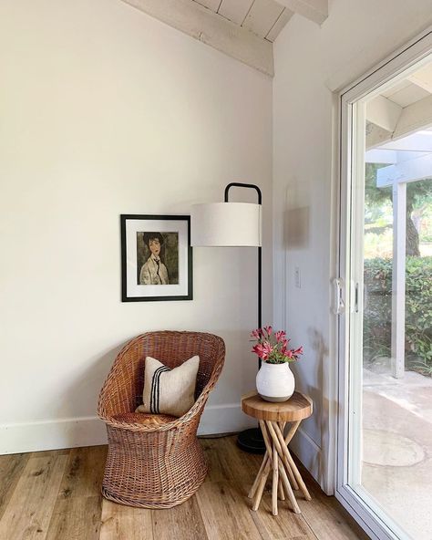 Vintage rattan wicker chair with textured pillow and wooden side table, natural wood stool and ceramic vase, modern floor lamp with black base and white drum shade, modigliani black framed portrait painting Framed Portrait, Modern Floor Lamp, Vintage Rattan, Vase Modern, Wooden Side Table, Modern Floor, Wood Stool, Pillow Texture, Portrait Frame