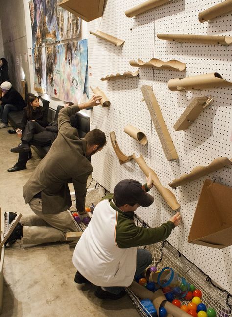 An oversized cross between pachinko and a marble run, this interactive installation invites people to place cardboard tubes of various length and diameter onto a grid of pegs protruding horizontally from a wall. Maker Fun Factory Vbs, Maker Fun Factory, Wooden Objects, Interactive Walls, Marble Run, Interactive Installation, Interactive Art, Childrens Museum, Vacation Bible School