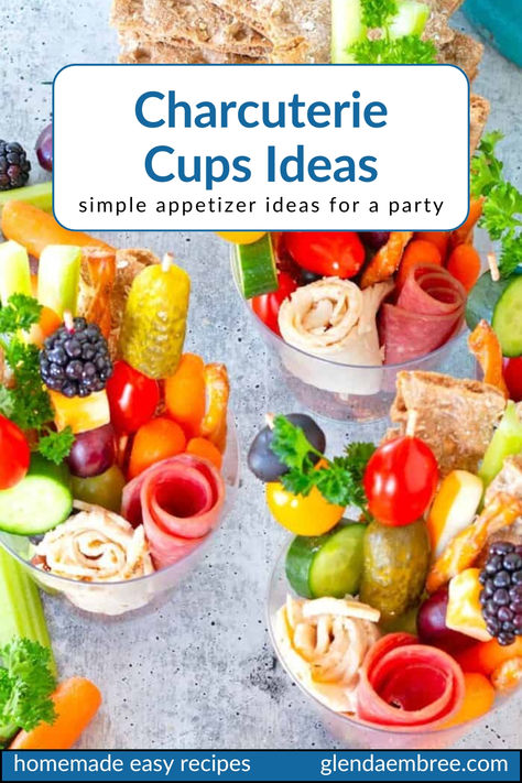 Various charcuterie—rolled slices of deli meat, skewers of cheese cubes and fruit chunks, nuts, pretzel sticks and fresh veggie sticks in  clear plastic cups for individual appetizer portions. Snack Cup Ideas Parties Food, Charcuterie Cups Recipes, Teacup Charcuterie, Charcuterie Cups Baby Shower Ideas, Charcuterie Cup Ideas Easy, Snack Cups For Party, Charcuterie Cups For Wedding, Make Ahead Charcuterie Cups, Charcuterie Party Cups