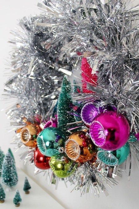 A little garland and tinsel go a long way in this mid-century modern inspired wreath. This eye-catching DIY can be done in an afternoon. Tinsel Wreath Christmas, Mid Century Modern Holiday Decor, Tinsel Wreath Diy, Silver Christmas Trees, Tinsel Wreath, Winter Wreath Diy, Retro Christmas Decorations, Silver Wreath, Mid Century Modern Christmas