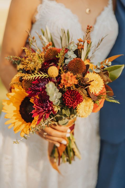 Autumn wedding at a Rustic Montana venue during golden hour! Fall Bouquet Wedding Sunflowers, Terracotta Wildflower Bouquet, Fall Bouquet Sunflower, Autumn Bridal Flowers, Fall Wedding Flowers Sunflowers, Flowers On Wine Barrels Wedding, Fall Wedding Ideas October Centerpieces, Whimsical Fall Bouquet, Simple Sunflower Wedding Bouquet