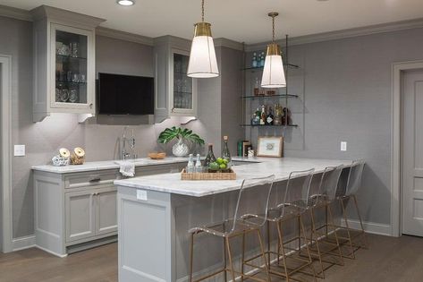 Gray basement bar boasts Gabby King Barstools placed at a gray peninsula topped with a white and gray countertop lit by two glass and brass pendants. Transitional Basement, Gray Basement, Finished Basement Designs, Basement Bar Plans, Basement Kitchenette, Modern Basement, Basement Bar Designs, Finished Basement Ideas, Grey Countertops