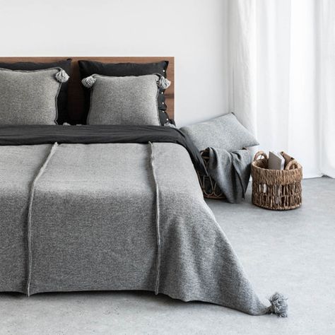 Double bedspread is made of a soft knitted woolen fabric. The raw finishes of the seams emphasise texture of the material. Simple design makes the bedspread suitable for any interior. Decorative heavyweight pom poms on both ends of the bedspread give it a unique character.