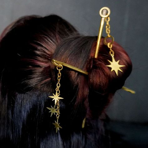 💫 Give your hair star power with the stars Dangle Hair Sticks—the cosmic accessory your locks have been waiting for! 🌟 With three shimmering stars dancing at the tips, the galaxy IS the main character. ( We're obsessed with space here if you hadn't noticed) And if you really want to level up the magic, pair it with other dangle hair sticks for a look that's out of this world! 🚀✨ Shop our website to level up to a true Space-queen. 👑 #StarPower #HairGoals #CosmicChic #DarkstarMachinations ... Fantasy Hair Accessories, Hair Jewerly, Elf Hair, Hairstyle Bun, Gold Hair Pin, Bun Updo, Chinese Hair, Fingernail Polish, Gold Hair Accessories