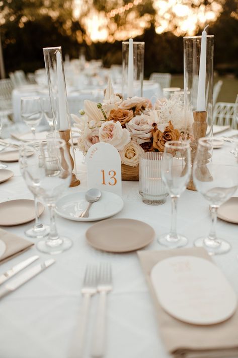 El Chorro wedding giving off Palm Springs vibes. White minimalist reception chairs and tableclothes. String lights complete the atmosphere and set up. Centerpieces were modern neutral florals with browns and tans. Geometric table numbers finish the look. This desert hip wedding is one to share!!