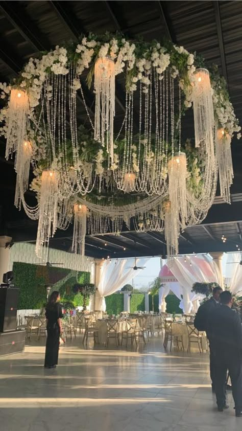 Have you ever seen anything like this? Our chandelier is a mixture of ivory hanging flowers, greenery leaves  and crystal beads followed by light that illuminates all around.  #Royalgarden #LuluJaramillo #Royalevents Crystal Hanging Decor Wedding, Chandelier Tent Wedding, Flowers Hanging From Ceiling Wedding, Hanging Flowers From Ceiling, Wisteria Chandelier, Flower Chandelier Wedding, Floral Chandelier Wedding, Bridal Suite Decor, Chandelier Flower