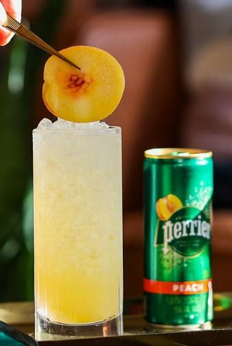 Peach Swizzle | Perrier Non-Alcoholic Mocktail Recipes Mocktail Recipes, Peach Puree, Peach Slices, Mocktail Recipe, Beverage Cooler, Mineral Water, Sparkling Water, Fresh Lemon Juice, Simple Syrup