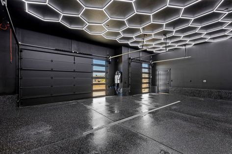 Hex lighting and black finished flooring complete this garage. All Black Garage Interior, All Black Garage, Black Garage Interior, Large Garage Ideas, Cozy Modern Home, Kitchen Cozy, Black Garage, Gym Garage, Great Falls Montana