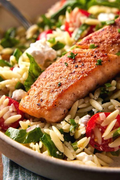 This Pan Seared Salmon with Orzo Salad recipe is proof that healthy eating can be easy AND delicious! Perfectly seared salmon that is crispy on the outside and tender and flaky on the inside is nestled in an veggie-packed orzo salad and dressed with a tangy red wine vinaigrette. Heart-healthy and bursting with flavor, this salmon recipe always disappears. Salmon With Orzo, Salmon Orzo Recipe, Lemon Orzo Salad, Orzo Salad Recipes, Salmon Salad Recipes, How To Cook Orzo, Orzo Pasta Salad, Red Wine Vinaigrette, Orzo Recipes