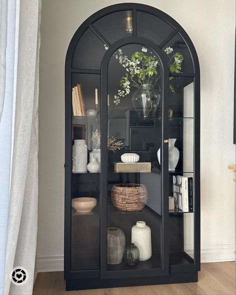 Curio Cabinet Displays Farmhouse, Black Arched Glass Cabinet, How To Style Curio Cabinet, Black Arched Cabinet Dining Room, Display Cabinet With Glass Doors, Curio Cabinet Styling Ideas, Arch Cabinet Makeover, Crystal Cabinet Display, Black Arched Cabinet Styling