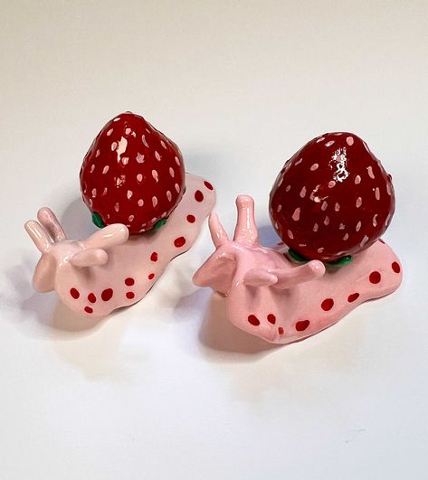 Shortcake is a sassy little snail who loves strawberries so much she decided to live in one! She may get angry if you try to eat her house so don't even try! This listing is for one (1) snail figurine.  Dimensions are estimates as each one is hand made and size could vary slightly. These figurines are entirely hand sculpted in polymer clay and sealed with resin for extra durability. Each one is made to order which makes each one unique. Because of this there may be some slight differences and although I have super high standards with my creations there is always a chance of tiny imperfections.  The resin makes them extra strong but still be gentle with them - they are meant for display and not a toy! If you want certain colors or want to ask about a custom snail, drop me a message! I love Clay Crafts Oven Bake, Snail Clay, Polymer Clay Decor, Snail Figurine, Clay Strawberry, Fruit Animals, Clay Candle, Get Angry, Air Dry Clay Projects