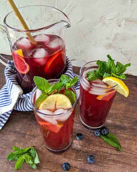 Sweet and refreshing blueberry iced tea is the perfect summertime BBQ picnic drink.  Easy to make using brewed tea and blueberry simple syrup. Fruit flavored iced tea is our go-to drink recipe because they are naturally sweet.   #icedtea #icetea #fruittea #tearecipe #nonalcholicdrinks #summerdrinks #drinksforacrowd #blueberries Flavored Iced Tea, Fruit Tea Recipes, Blueberry Syrup Recipe, Picnic Drinks, Blueberry Simple Syrup, Cold Brew Iced Tea, Mint Sugar, Blueberry Tea, Blueberry Syrup