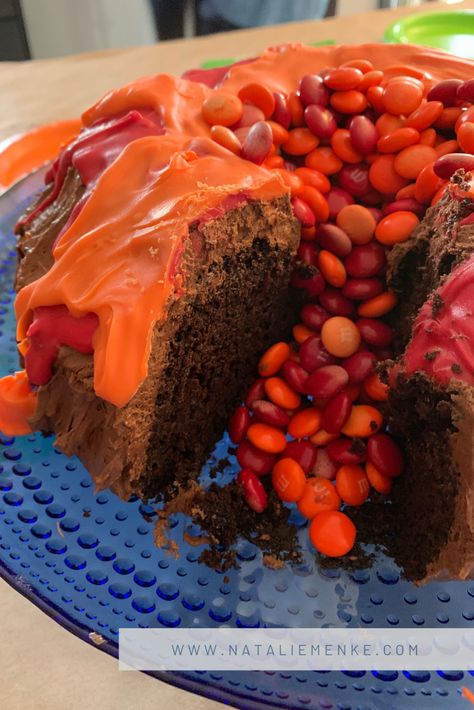 Volcano Birthday Party chocolate volcano bundt cake with M&M lava flow at www.nataliemenke.com #volcanocake #volcanoparty #volcanobirthdayparty #birthdaydecor #dinosaurparty #dinosaurbirthdayparty #birthdayparty #fouryearoldbirthdayparty #birthdaypartytheme #partytheme #kidsparty #kidparty #boybirthdayparty #girlbirthdayparty Hot Lava Birthday Party, Volcano Bundt Cake Dinosaur Party, Volcano Cake Easy, Dinosaur Bundt Cake, Volcano Food, Tower Birthday Cake, Volcano Cake Ideas, Donut Volcano Cake, Volcano Bundt Cake