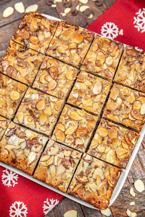 Almond Toffee Bars - pure dessert bliss! Layers of crunchy oats, graham cracker crumbs, toffee bits, chocolate chips, and sliced almonds, all held together by a sweet caramelized embrace of condensed milk. Perfect for holidays or any sweet occasion, these bars strike the perfect balance between sweet and indulgent. Make sure to add them to your baking list—you won't be able to resist this heavenly treat! Almond Caramel Bars, Almond Toffee Bars, Baking Bars, Crunchy Oats, Baking List, Almond Toffee, Almond Bars, Toffee Bars, Caramel Bars