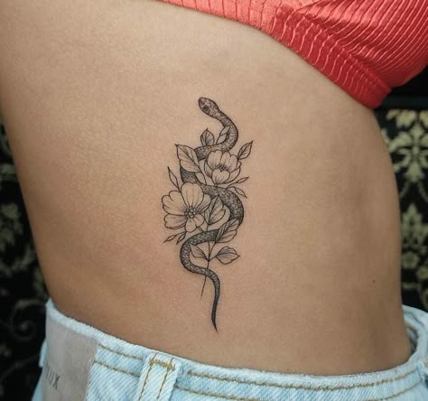 Small Snake Tattoo With Flowers, Snake Tattoos Flower, Snake Around Flower Tattoo, Small Snake With Flowers Tattoo, Snake Tattoos Rib Cage, Delicate Snake Tattoos For Women, Snake And Lily Tattoo, Divine Feminine Snake Tattoo, Snake Rib Tattoos For Women