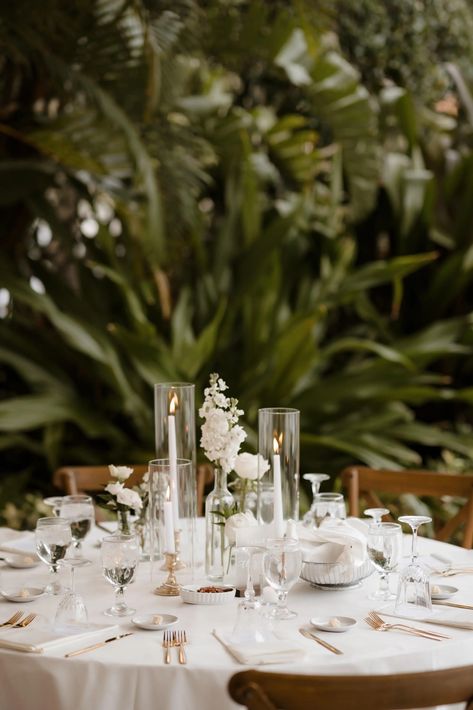 Elegant Italian Inspired Wedding Reception Tablescape Ideas | Rustic Wooden Cross-Back Chairs, White Taper Candles with Hurricane Tube Glass, White Rose in Bud Vases Centerpiece Inspiration Taper Candle And Bud Vase Centerpiece, Candle And Roses Centerpieces, 3 Vase Centerpiece Ideas, Bud Centerpiece Wedding, Classic Elegant Wedding Reception Decor, Rose Bud Vase Centerpiece, Candles And Bud Vase Centerpiece, White Rose Table Decor, Tapered Candles Wedding Centerpieces