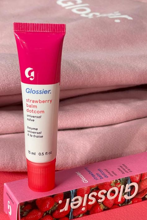 Meet Glossier Strawberry Balm Dotcom! 🍓 The iconic do-everything formula now in a sweet, juicy strawberry flavor with a jammy red tint. This balm nourishes lips with a blend of heavy-duty moisturizers and antioxidants, perfect for keeping dry, chafed skin at bay. Its thick texture and water-binding properties lock in moisture for soft, hydrated lips. #Glossier #StrawberryBalmDotcom #LipCare Glossier Strawberry Balm Dotcom, Glossier Strawberry, Sephora Stuff, Glossier Campaign, Chafed Skin, Back To School Makeup, Glossier Lip Balm, Hydrated Lips, Birthday Things