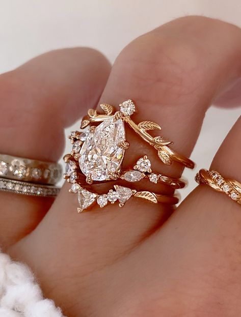 Harmony is a whimsical rose gold engagement ring that embodies the perfect balance of nature-inspired elegance and vintage charm. Our Adelixa acts as her leafy crown with a pop of sparkle. Kya completes this stack with her collection of trillion and round cut diamonds, and a dainty leaf engraving sits on either side to tie in an element of nature. Drop-down diamond options represent our recommended grade, which maximizes size for value, while maintaining eye-perfect clarity and giving you a colorless look. For other diamond options, see our Shop Diamonds tab or speak to one of our design consultants. This design can also be made with other stone shapes. Rings in this set can be purchased separately by visiting the individual product pages. Harmony's setting only cost: 14k Rose, White, or Y