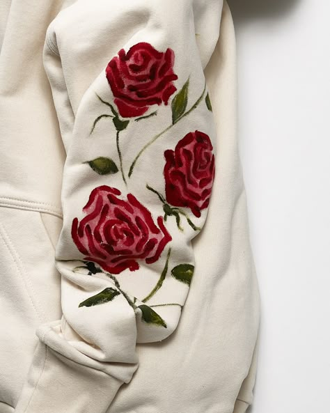 We applied our hand painted roses to the Summer Hoodie. A beautiful statement piece that will keep you cozy all year round! Features Hand painted trio of red roses on the left arm. Specialty wash-fast fabric paint, washable & dryer safe. Single lined hood and pouch pocket for a lighter weight feel. 5 thread serge & topstitched seams - for durability and longevity. Flatlock side, arm & hood seams - for bulk reduction and smoother finish inside and out. Designed, cut, sewn & painted in our factory Painted Hoodies Ideas, Painting Ideas On Hoodie, Art On Hoodies, Paint Hoodie Diy, Hoodie Diy Paint, Painting On Sweatshirts, Painting On Hoodies Ideas, Diy Hoodie Design Paint, Paint Shirt Design