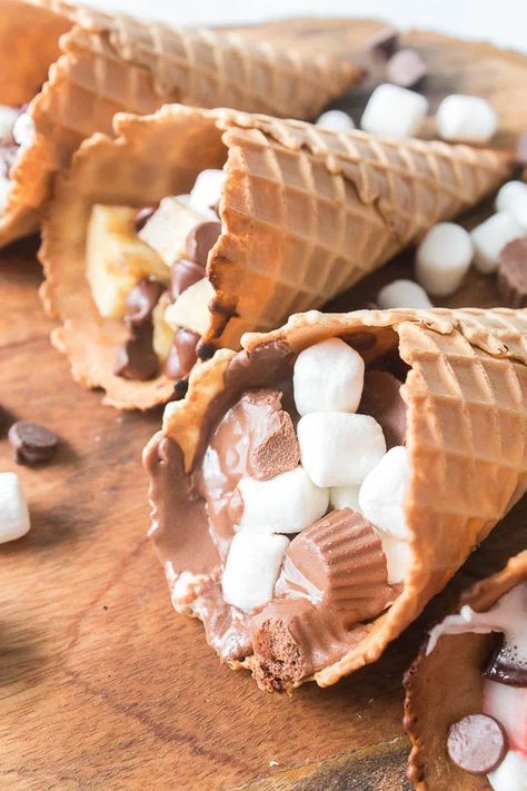 These Waffle Cone Smores are a fun treat any time of year. A summer twist on a fall treat or a fall twist on a summer treat – You decide! These Waffle Cone Smores are a delicious treat whichever way you cook them, but let's be honest - it's most fun to cook on the grill! Waffle Cone Smores, Cone Smores, Campfire Cones, Waffle Cone, Waffle Cones, Fall Treats, Treat You, Fun Treats, On The Grill