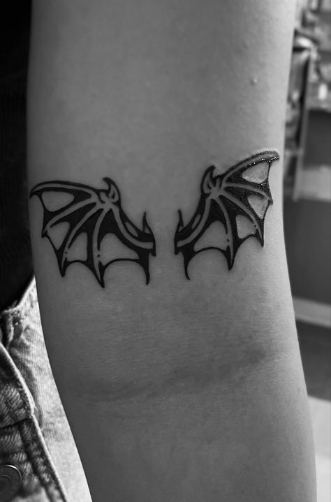 Photo of a bat wings tattoo located above the inner arm ditch Batwing Tattoos, Spooky Tattoos Traditional, Bat Wing Tattoo Back, Goth Stick And Poke, Collar Bone Tattoo Traditional, Bat Outline Tattoo, Angel And Bat Wing Tattoo, Bat Tattoo Arm, Bat Patchwork Tattoo