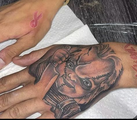 Chucky Tattoo On Hand, Chunky Hand Tattoo, Chucky Tattoo Hand, Hood Arm Tattoos, Black Male Hand Tattoos, Hand Tattoos For Black Guys, Black Men Neck Tattoo Ideas, Hood Hand Tattoos, Hand Tattoos For Black Men