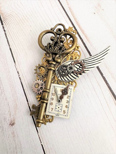 Three styles, each One of a Kind Steampunk Brooches. See the creative choices in these unique brooches. Each brooch is made with a large brass old fashion key, on gold filigree. Each brooch has a one of a kind unique clock face, and each have a large silver metal wing, and an assortment of Gears. They each have a pin on the back. Each brooch is about 3.5 inches tall, and 2.5 inches wide. These Steampunk brooches can be a part of your collection of Steampunk Jewelry. Great unisex jewelry for wom Steampunk Accessories Mens, Unique Brooches, Old Fashioned Key, Steampunk Items, Steampunk Key, Mode Steampunk, Steampunk Aesthetic, Steampunk Halloween, Metal Wings