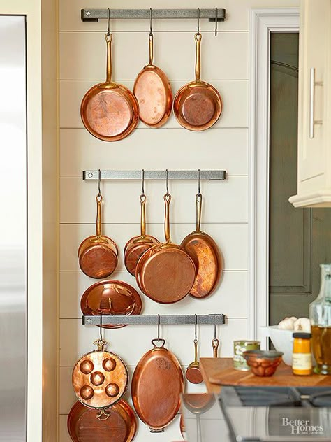 Industrial stainless-steel racks hold a collection of vintage copper pots. The contemporary mix of metals elegantly contrasts with this kitchen's traditional-style wood-plank walls. Hang Pots And Pans, Copper Pots And Pans, Pallet Deck Diy, Vintage Copper Pots, How To Clean Copper, Home Tips And Tricks, Pot Racks, Timeless Kitchen, Deco Retro