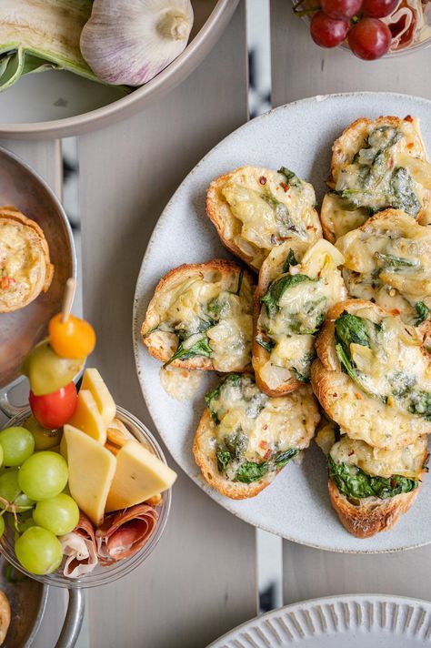 Spinach Artichoke Bruschetta | Baked Bree Spinach Artichoke Crostini, Spinach And Artichoke Crostini, Spinach Artichoke Appetizer, Christmas Appetizers For Party, Artichoke Crostini, Clams On The Grill, Grazing Cups, Artichoke Bruschetta, Christmas Appetizers Recipes