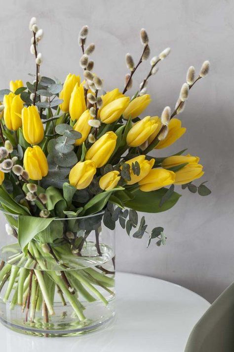 a clear vase with yellow tulips and willow plus a bit of eucalyptus is a lovely and bold spring flower arrangement Easter Flower Arrangements, Tulips Arrangement, Deco Champetre, Spring Flower Arrangements, Spring Arrangements, Spring Floral Arrangements, Flower Vase Arrangements, Tulips In Vase, Easter Flowers