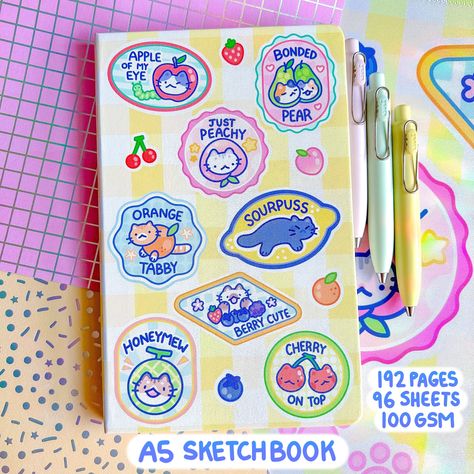 IMPORTANT: For US/Canada/Mexico based Customers, my SHOPIFY link has lower prices available! https://starmintart.com We combined the cute aesthetic of fruit stickers with fun cat puns, and now our Fruit Kitty Committee is available as a sketchbook cover! Our newest sketchbooks are both aesthetic and sturdy, with nice hardcovers and a vibrant faux leather printed cover. Within its pages you will find a warm white-toned paper that is 100 gsm, adding up to 192 total pages, aka 96 sheets.  The smoot Monthly Journal Cover, Cat Picnic, Pinterest Wishlist, Picnic Fruit, Retro Cherry, Faux Leather Journal, Fruit Stickers, Journal Cute, Stationery Obsession