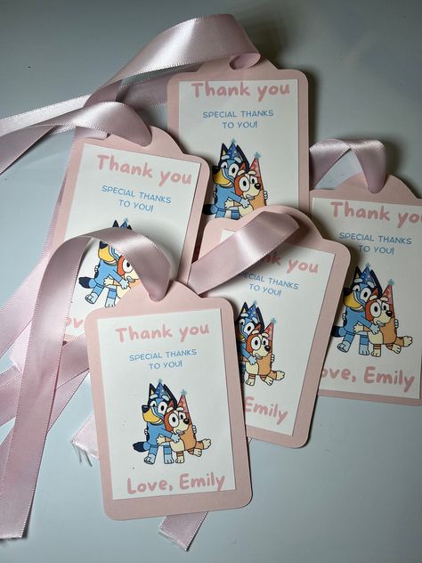 NO RETURNS, NO REFUNDS, NO EXCHANGE Please read descriptions carefully. By purchasing you have read and agreed to our terms and conditions. Add a touch of Bluey magic to your next celebration with our adorable Bluey Themed Favor Tags! 🎉  These favor tags are not only a wonderful addition to your party decor but also make great keepsakes for your guests to cherish. They can be attached to party favors, gift bags, cupcakes, or even used as table decorations. Your guests will love them, and your little Bluey fan will be over the moon! Product Details: - Made from high-quality cardstock - Vibrant, full-color printing - Pre-cut holes for easy attachment with ribbon - 11" light pink ribbon Bluey Themed Party, Bingo Party, 2nd Birthday Party For Boys, Dog Themed Parties, Bluey Party, Bluey And Bingo, Bluey Birthday, Peppa Pig Birthday, Birthday Party Tables