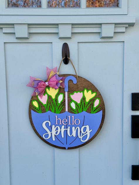 Spring showers, bring May flowers! This door hanger is the epitome of Spring and so gorgeous in person! We offer this door sign in two sizes: 15 inch and 18 inch. Please select the size you prefer before adding it to your cart! Most items are made to order, so please allow two weeks for us to create your item especially for you. Bow fabric may vary slightly from the photo. Wood Front Door Sign, Hello Spring Door Hanger, Spring Door Signs Diy, Spring Door Hangers Wooden, Spring Door Hangers Diy, Spring Wooden Door Hangers, March Door Decorations, Spring Signs Wooden, Circle Door Signs Diy