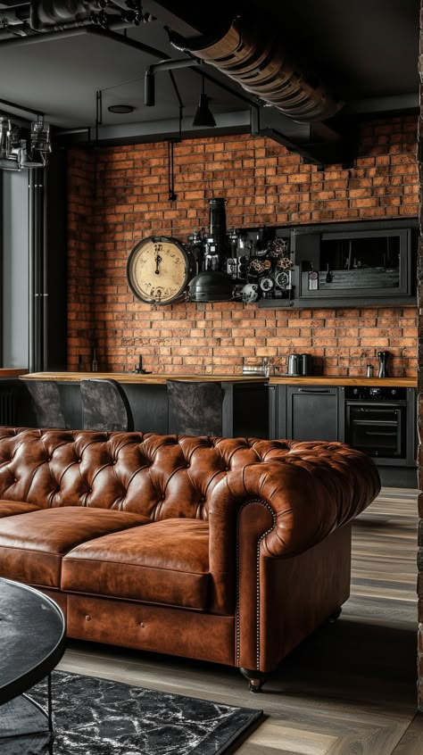 Cozy industrial-style living room with a brown leather Chesterfield sofa, brick walls, wood accents, and a steampunk kitchen Leather Tuffed Couches, Leather Couch Coffee Shop, Leather Accents Living Room, Brown Chesterfield Sofa Living Room, Industrial Cozy Living Room, Red Brick Wall Living Room, Brown Apartment Aesthetic, Leather Brown Couch, Dark Brown Leather Sofa Living Room