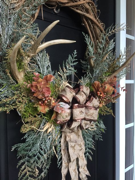 Rustic fall or winter wreath with antlers in a grape vine wreath with Green pines...grasses...leaves...and deer ribbon bow Wreath With Deer Antlers, Rustic Christmas Mantel, Antler Wreath, Antler Ideas, Rustic Christmas Wreath, Deer Decor, Tree Wreath, Pine Wreath, Trend 2024