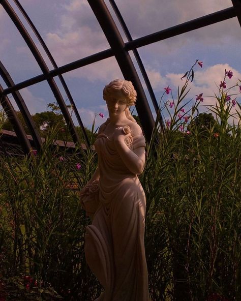 Statues In Gardens, Garden Goddess Art, Spring Goddess Aesthetic, Daughter Of Persephone Aesthetic, Statue In Nature, Daughter Of Aphrodite Aesthetic, Persephone Statue, Greek Statues Aesthetic, Statue With Flowers