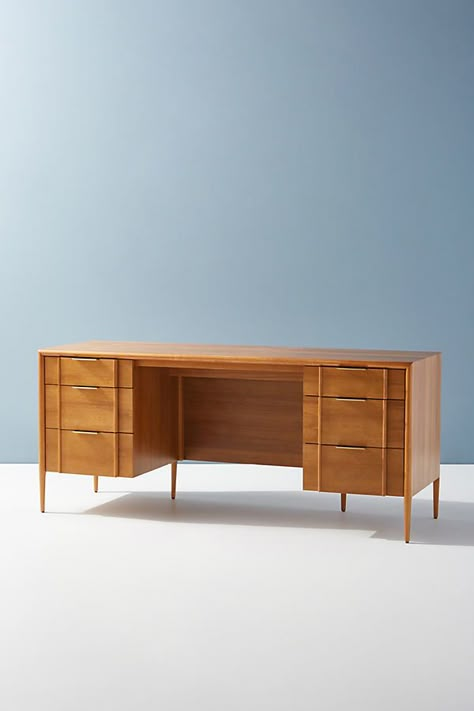 Offering a contemporary twist on a midcentury-inspired silhouette, this executive desk features an external border element that frames its shape and tapers to the leg. Understated brass hardware complements the beautiful grain of the wood without clashing or distracting, while sculpted drawer fronts add a layer of texture that draws the eye. With ample storage and functionality from its flanking drawer sets, this desk is a beautiful centerpiece for a home office or workspace. For ordering assist Office And Music Room, Girlie Office, Airy Office, Hamptons Office, House Office Ideas, Mid Century Modern Office Desk, Moody Academia, Midcentury Modern Office, Nyc Apartment Design