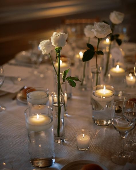 Simple single white roses and candles wedding table decor Single Stem Table Decor Wedding, Minimalist White Rose Centerpiece, Single Rose Table Centerpiece, Simple Rose Table Centerpieces, Tea Light Candles Wedding Centerpieces, Single Rose Centerpiece Simple, Single Roses Wedding Table, Single Rose In Vase Wedding, Candle Light Birthday Decoration