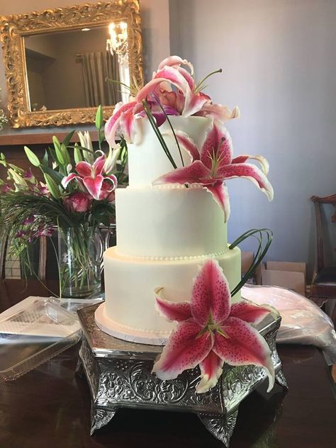 A beautiful and classic wedding cake with pink stargazer lilies! Wedding Cake With Lilies, Lily Cake Birthday, Lily Flower Cake, Lily Birthday Cake, Wedding Lilies, Wedding Cake Aesthetic, Stargazer Lily Wedding, Tropical Birthday Cake, Wedding Cake With Pink