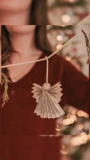 Cathryn Wood on Instagram: "🪽✨ DIY Paper Angel Garland ✨🪽 The cutest little garland. These paper angels are so easy to make, you could also make them as ornaments for the tree or as an extra on gifts! To make your own you will need: Book paper or Christmas paper Wooden beads (I got mine from @theworksstores ) Glue gun Macrame twine/ twine or ribbon - Cut the book pages 2/3. Discard the third for future crafts. - Concertina fold each book page. Then fold the book page 1/3 down. This creates the angels wings. - Place the wooden bead on the twine and glue the longest part of the twine to the inside of the fold. Glue the other book page to the twine too. - Glue the wooden bead to the top of the angel to create the head. - Finally glue the inner edge of the wing to the main body Paper Angels Diy, Angel Garland, Book Page Garland, Paper Angels, Angels Wings, Paper Angel, Diy Christmas Garland, Gifts To Make, Angel Books