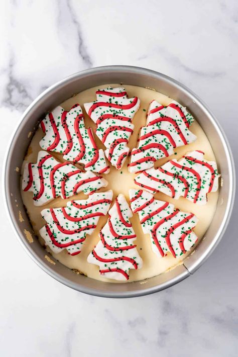 This Little Debbie Christmas Tree Cheesecake is a delightful mashup of creamy vanilla cheesecake stuffed with our favorite holiday snack cakes and topped with white chocolate ganache, the iconic red icing stripes, and green sugar sprinkles! It's a fun and festive treat that is sure to delight everyone this Christmas! | little debbie christmas tree cheesecake recipe | little debbie christmas tree cheesecake incredible recipes | best christmas cheesecake Christmas Tree Cheesecake Recipe, Little Debbie Christmas Tree Cheesecake, Christmas Tree Cheesecake, Xmas Desserts Recipes, Cheesecake Christmas, Little Debbie Snack Cakes, Red Icing, Little Debbie Christmas Tree, Debbie Snacks