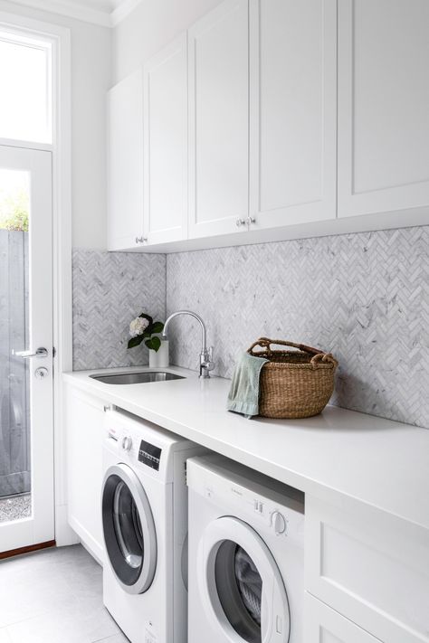 A spacious, light-filled Hamptons home in Melbourne's inner-east | Home Beautiful Warm Oak Floors, Minimal Laundry Room, Hamptons Laundry, Herringbone Splashback, Gray Herringbone Tile, Minimal Laundry, Laundry Tiles, Minimalist Laundry Room, Hamptons Style Laundry