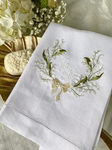 "A lovely and stunning design of a frame of lilies of the valley embroidered in our white, 100% pure linen, hemstitched guest towels. In this white-on-white design, the embroidered off- white thread lifts the intricate bell-shaped flowers and, together with the green thread of the leaves, echoes beautifully the spring season to come.  Charmingly placed in the middle of the flower frame, goes your monogram of choice in a very delicate and romantic font.  These personalized towels will definitively add a special touch to your guest bathroom or powder room and, if properly cared, can be a heirloom piece to pass on generations.   Color of thread for the monogram or any other decorative element of the design may be customized upon your preference. Just send us a message to work together on your Ladies Brunch, Lilies Of The Valley, Linen Guest Towels, Romantic Fonts, Monogrammed Linens, Embroidered Napkins, Guest Towel, Personalized Towels, Mary Elizabeth