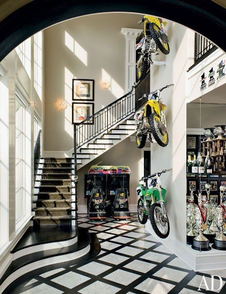 Motorcycles are displayed against a double-height wall in racer Ricky Carmichael's Tallahassee, Florida, home. Dirt Bike Room, Bike Room, Dirt Bike Girl, Painted Stairs, Motocross Bikes, Sports Stars, Dirt Bikes, Bike Life, Architectural Digest